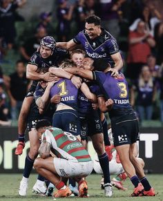 a group of rugby players huddle together on the field