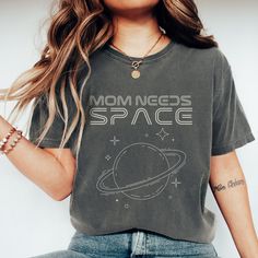 Mom Needs Space T-Shirt, the perfect celestial garment for all the cosmic moms out there! Designed with a whimsical touch, this shirt is a delightful blend of humor and science fiction, ideal for astronomy enthusiasts, science fiction aficionados, and anyone with a celestial sense of humor. Crafted on the ultra-soft Comfort Colors 1717 fabric, this t-shirt ensures both comfort and style. Its relaxed fit and breathable material make it perfect for everyday wear, whether you're exploring the unive Space-themed Cotton Crew Neck Top, Space-themed Cotton Top With Graphic Print, Space-themed Crew Neck Top With Letter Print, Space-themed Letter Print Crew Neck Top, Space Tshirt, Present For Christmas, Mom Needs, Space Shirts, Funny Mom Gifts