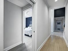 an empty hallway with white walls and wood floors