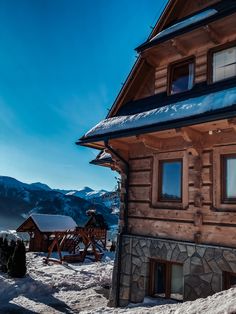 a wooden house with snow on the ground