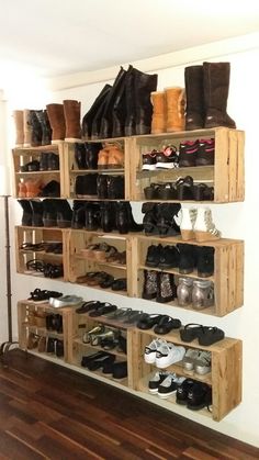 a wooden shelf filled with lots of pairs of shoes on top of a hard wood floor