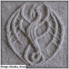 a close up of a knitted object on a tablecloth with the word's logo