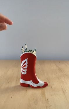 a red and white boot with toothpicks in it sitting on a wooden table