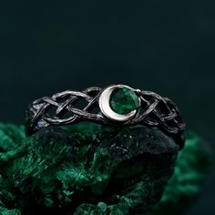 a silver ring sitting on top of a green rock