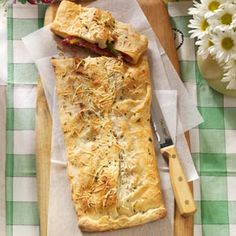 there is a pastry on the cutting board next to flowers