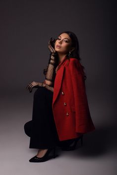 a woman in a red coat and black pants