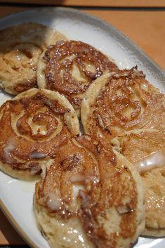 some cinnamon rolls are on a white plate