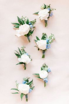 white and blue flowers are arranged on a table