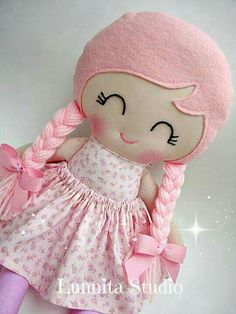 a stuffed doll with pink hair and dress