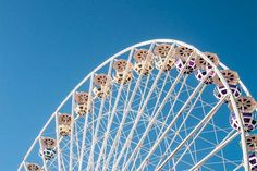 a large ferris wheel on a clear day with blue sky in the backround