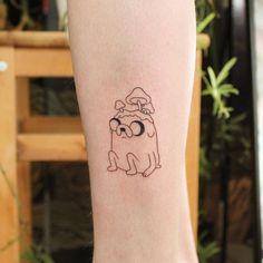 a small black and white dog tattoo on the right leg, with a santa hat