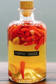 a glass bottle filled with sliced carrots on top of a wooden table