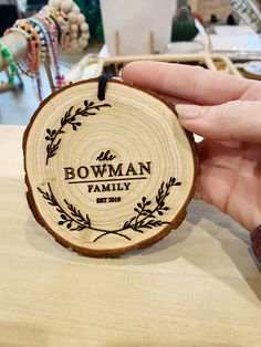 a hand holding a piece of wood that says bowman family