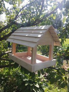 a wooden bird house hanging from a tree