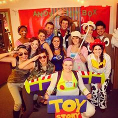 a group of people posing for a photo in front of a toy story sign and characters