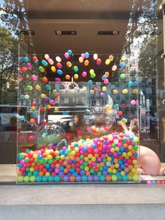 a display case filled with lots of colorful candies in front of a store window