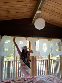 a woman standing on top of a bed in front of the word boo spelled out