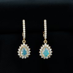 Product Details Bridal teardrop earrings crafted in gold, featuring pear-cut Ethiopian opal and round moissanite gems. These earrings are a stunning choice for your special day, adding charm to any bridal look. The elegant combination of the pear-cut opal and round moissanite gems creates a beautiful contrast and shine brightly against the gold setting. Ideal for the bride who wants a touch of timeless sophistication on her wedding day, these earrings are the perfect finishing touch. They are de Teardrop Bridal Earrings, Round Moissanite, Earring Crafts, Bridal Look, Pear Cut, Bridal Looks, Bridal Earrings, Teardrop Earrings, Ethiopian Opal