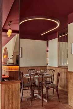 a restaurant with wooden tables and chairs in the center, along with red painted walls