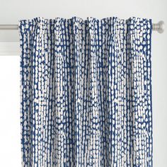 blue and white curtains hanging on the side of a window