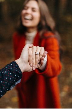 two people holding hands and smiling at each other