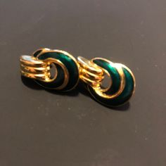 Vintage 80s Trifari pierced earrings in gold, featuring an elegant swirl design with emerald green accents. Each piece is signed by the artist, adding a touch of authenticity to your collection. * Vintage 80s design * Pierced earrings * Gold swirl design * Emerald green accents * Signed by Trifari Size: Womens 1" Condition: Pre-Owned Green Clip-on Earrings For Formal Occasions, Green Metal Drop Clip-on Earrings, Green Clip-on Formal Earrings, Green Metal Clip-on Earrings, Retro Green Drop Earrings, Retro Green Earrings For Party, Green Clip-on Jewelry For Evening, Green Clip-on Metal Earrings, Green Retro Party Earrings