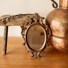 an old mirror sitting on top of a wooden table