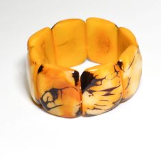 This beautiful organic Tagua Nut Mustard Yellow Chunky Statement Bracelet is a combination of luxury and elegance at its best.   If you desire the luxury of ivory, think of Ecuador's rain forests, where ivory is so abundant that it grows on trees! Make a statement without saying a word!  SIZE This Tagua Bracelet is connected with two strands of elastic. Each Tagua piece is approximately 1.25" in length. The bracelet measures 7" in circumference (inner).  RECOMMENDED NECKLACE https://www.etsy.com Elegant Amber Bangle Bracelet, Elegant Amber Bracelets For Formal Occasions, Yellow Bangle Bracelets For Formal Occasion, Elegant Amber Bangle Jewelry, Elegant Adjustable Rectangular Cuff Bracelet, Yellow Bangle For Formal Occasions, Elegant Yellow Bracelet As Gift, Elegant Yellow Bracelet As A Gift, Elegant Rectangular Cuff Bracelet