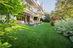 an apartment building with lawn and landscaping in the foreground