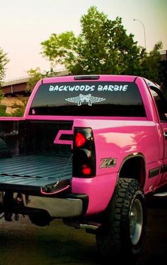 a pink pick up truck parked in a parking lot with the back door open to show the bed cover