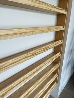 a wooden shelf sitting next to a white wall