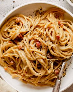 a white bowl filled with pasta on top of a table