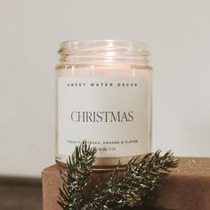 a candle sitting on top of a wooden block next to a christmas tree ornament