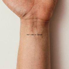 a person's wrist with the words your time is limited on it