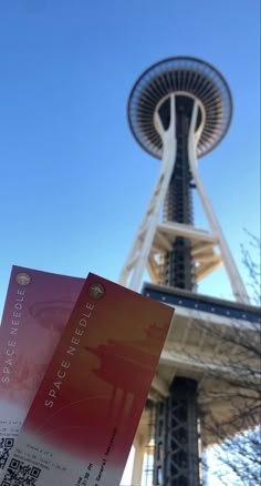 someone holding up a ticket in front of the space needle