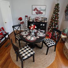 a dining room table set for christmas with plaid chairs and place mats on the floor