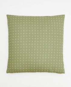 a green pillow with white dots on it