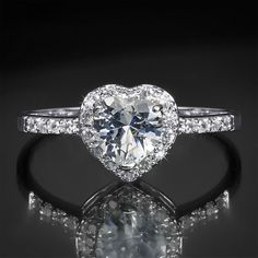 a heart shaped diamond ring with diamonds around it