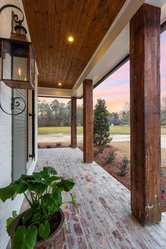 the porch is covered with wood and has a potted plant in front of it