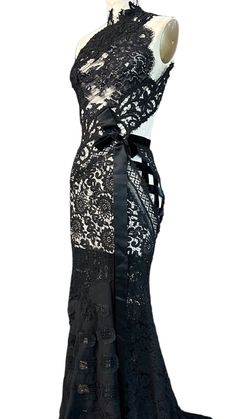 This gown is one of a kind and made using antique laces from the 1920s & 1930s with a central panel of handmade silk lace dating back to the 1880s. Vintage condition: Excellent Measurements Overall length: in. Garment width: in. US: XS Black Lace Gown With Lace Trim, Fitted Lace Bodice For Evening, Lace Evening Dress With Lace Patchwork, Lace Gown With Lace Sleeves For Evening, Fitted Evening Gown With Lace Patchwork, Evening Gown With Lace Patchwork, Lace Gown With Lace Trim For Evening, Lace Evening Gown With Lace Work, Floor-length Lace Dress With Lace Work For Evening