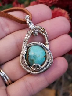 This little pendy has been handmade with love! Nice beautiful Turquoise Cabochon wrapped in Sterling silver wire with Aquamarine and Tourmaline accents. American Turquoise has some inclusions on the front not 100% sure what the other mineral is but possibly flourite? Unique swinging design! This pendant is in the smaller medium size range. 43mm tall and 24mm from to side. Wire wrap has a simple pattern. Simple but beautiful, this wrap is perfect for gifting! I wrap all my pendants by hand, the o Artisan Wire Wrapped Chrysocolla Jewelry, Handmade Artisan Turquoise Oval Necklace, Handmade Artisan Oval Turquoise Necklace, Artisan Handmade Oval Turquoise Necklace, Handmade Spiritual Turquoise Necklace With Round Pendant, Unique Wire-wrapped Turquoise Pendant Necklace, Unique Wire Wrapped Turquoise Pendant Necklace, Artisan Hand Wrapped Jewelry With Round Pendant, Handmade Unique Oval Turquoise Necklace