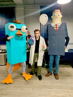 two men standing next to each other in front of some paper cut out characters and balloons