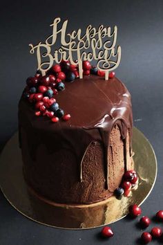 a birthday cake with chocolate frosting and berries