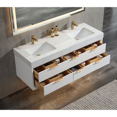 a bathroom vanity with two white sinks and gold faucets on the counter top