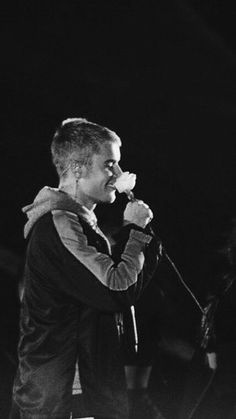 black and white photograph of a man singing into a microphone