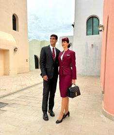 a man and woman standing next to each other in front of a building with windows