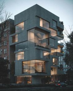 an apartment building with many windows and balconies on the top floor is lit up at night