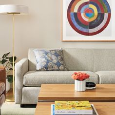 a living room filled with furniture and a painting on the wall above it's coffee table