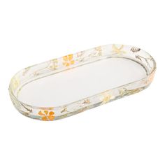 an oval glass tray with flowers on the bottom and yellow trimmings, sitting on a white surface