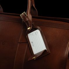 Every bag benefits from an instantly recognizable travel tag. The Signature leather luggage tag adds both style and practicality, ensuring your bag is easy to identify or returned to its rightful owner by honest hands. Featuring a brass buckle and a flap opening where your personal information is securely visible under a transparent cover, this refined leather luggage tag is handmade from the highest quality vegetable-tanned Italian leather with beautifully distinct stitching around the edges th Classic Brown Travel Accessories For On-the-go, Classic Everyday Rectangular Travel Accessories, Rectangular Brown Travel Accessories For Business Trips, Classic Rectangular Travel Accessories For Weekend Trips, Classic Travel Bags With Rfid Blocking, Classic Luggage For Weekend Trips With Sleeve, Classic Luggage For Weekend Trips With Luggage Sleeve, Classic Travel Accessories With Rfid Blocking For Everyday, Classic Travel Accessories With Luggage Sleeve